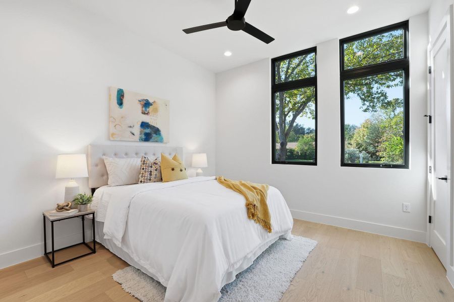 Bedroom with light wood-style floors, a ceiling fan, and recessed lighting