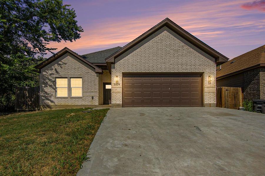 Ranch-style house featuring driveway, an attached garage, and brick siding