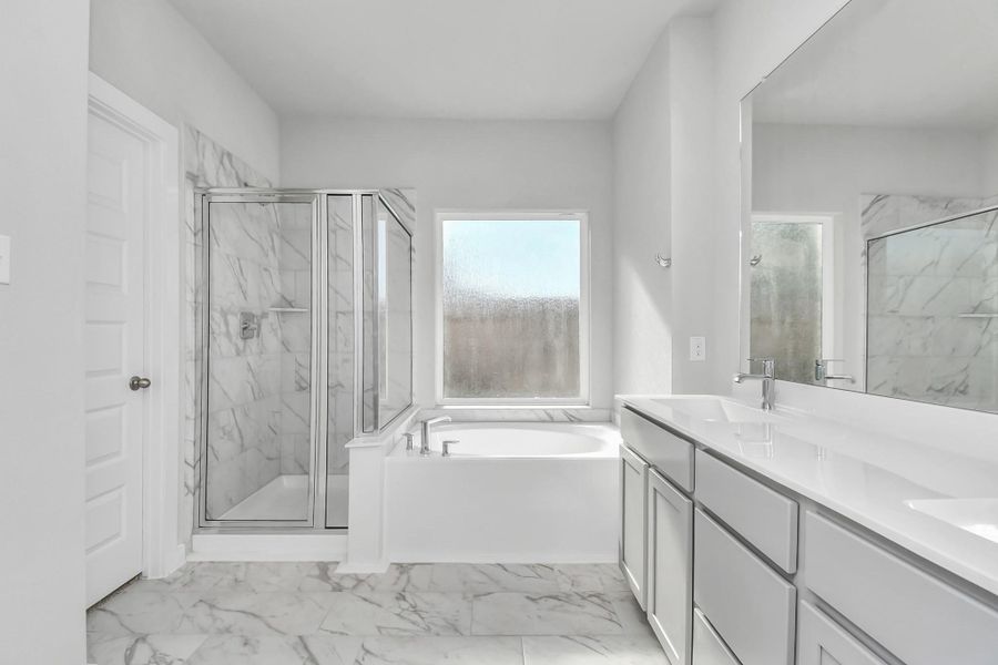 Escape to a spa-like oasis in this primary bathroom. Enjoy a walk-in shower with tile surround, a separate garden tub with custom detailing, and an elegant vanity featuring light countertops, modern hardware, and beautiful recessed lights. Experience luxury and relaxation in every detail. Sample photo of completed home with similar floor plan. Actual colors and selections may vary. Escape to a spa-like oasis in this primary bathroom. Enjoy a walk-in shower with tile surround, a separate garden tub with custom detailing, and an elegant vanity featuring light countertops, modern hardware, and beautiful recessed lights. Experience luxury and relaxation in every detail. Sample photo of completed home with similar floor plan. Actual colors and selections may vary.