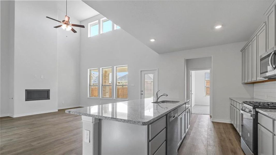 Kitchen featuring gray cabinets, light stone countertops, dark wood-style floors, ceiling fan, and recessed lighting