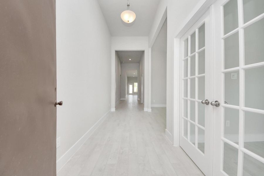 As you step into the threshold of this luxurious home, you'll soon be welcomed by an elegant glass door (to be installed). Inside, soaring ceilings amplify the spaciousness, while the refined wood-look tile flooring and oversized baseboards exude sophistication and charm. Sample photo of completed home with similar floor plan. Actual colors and selections may vary.