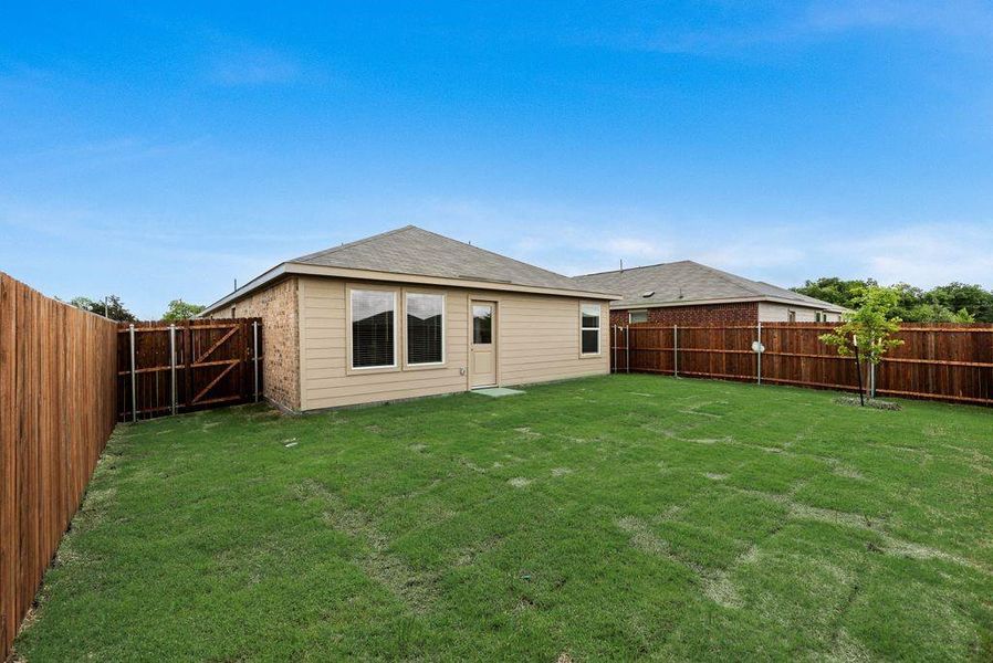 Rear view of property featuring a fenced backyard and roof with shingles