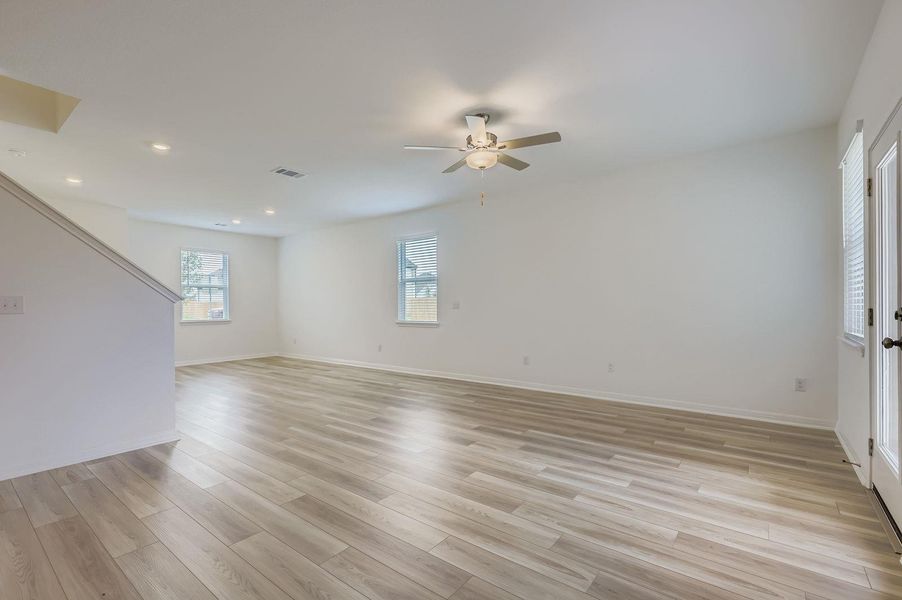Empty room with light wood finished floors, a ceiling fan, and recessed lighting Empty room with light wood finished floors, a ceiling fan, and recessed lighting