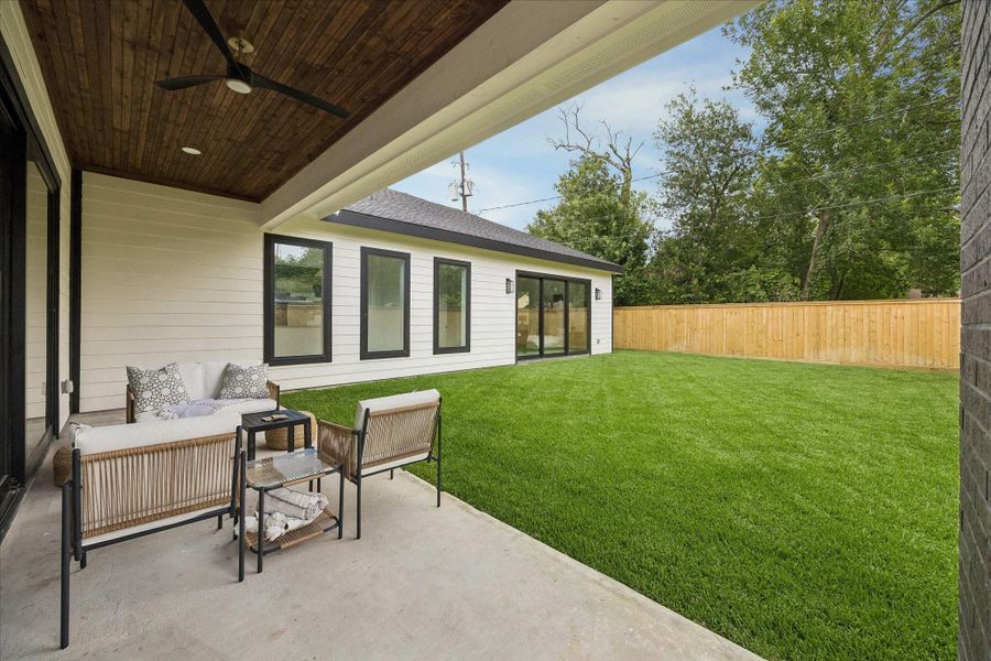Covered outdoor patio with stained wood ceiling detail, seamlessly connecting the interior living spaces to a spacious private backyard. Covered outdoor patio with stained wood ceiling detail, seamlessly connecting the interior living spaces to a spacious private backyard.