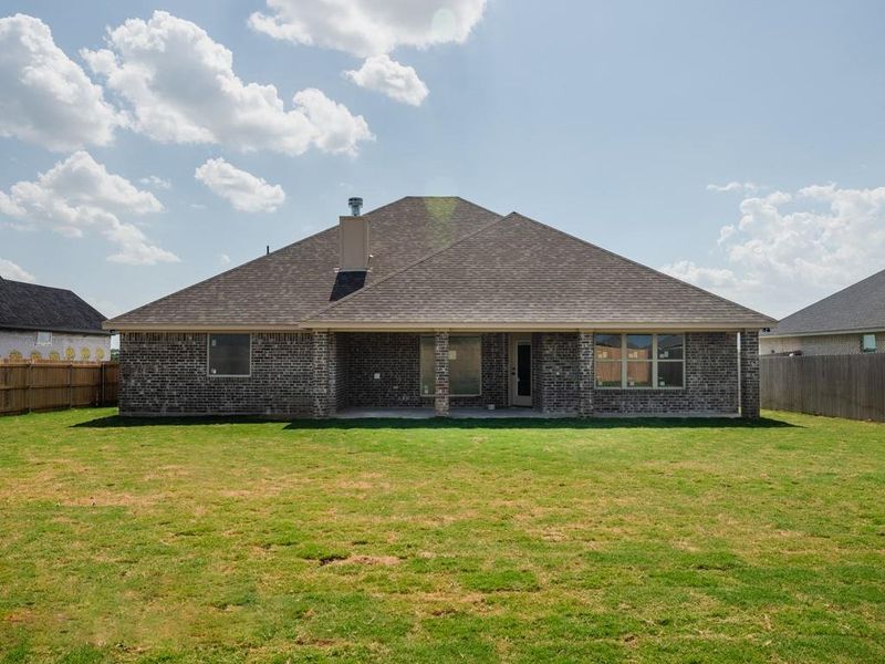 Back of property with a fenced backyard, a patio, brick siding, and roof with shingles Back of property with a fenced backyard, a patio, brick siding, and roof with shingles