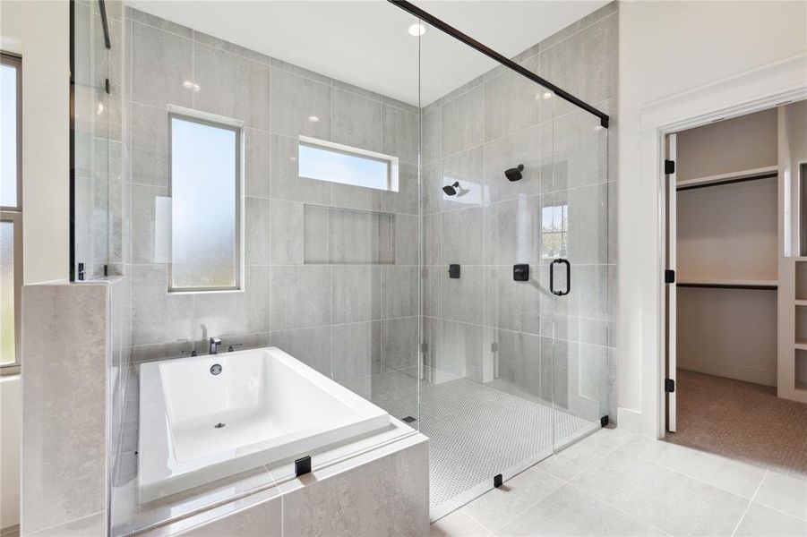 Bathroom featuring tile patterned floors, shower with separate bathtub, and tile walls