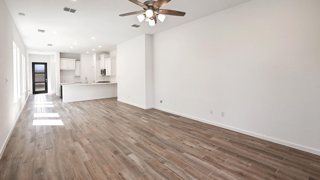 Unfurnished living room with light wood-style floors, ceiling fan, and recessed lighting Unfurnished living room with light wood-style floors, ceiling fan, and recessed lighting