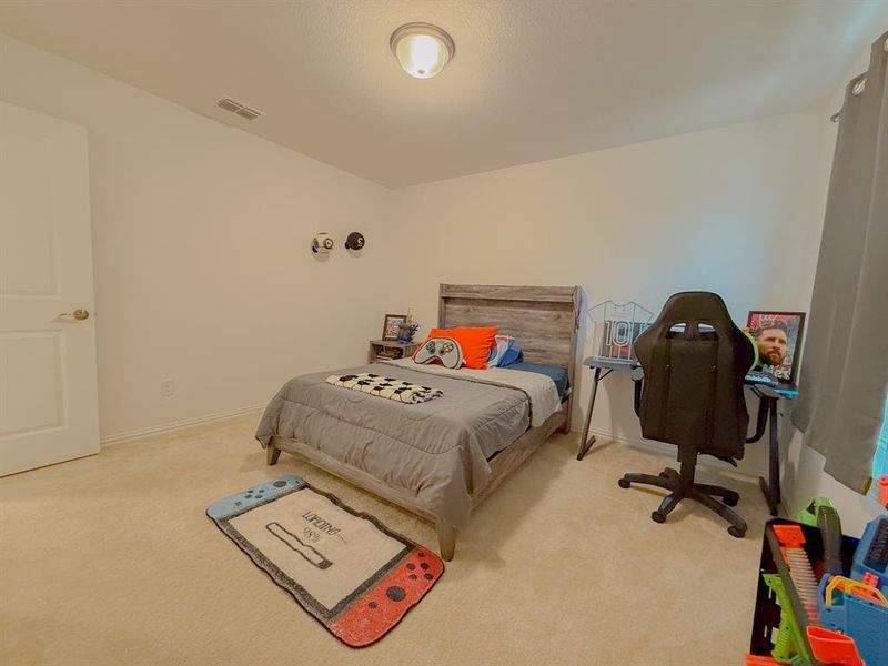 Bedroom featuring carpet floors, visible vents, and baseboards