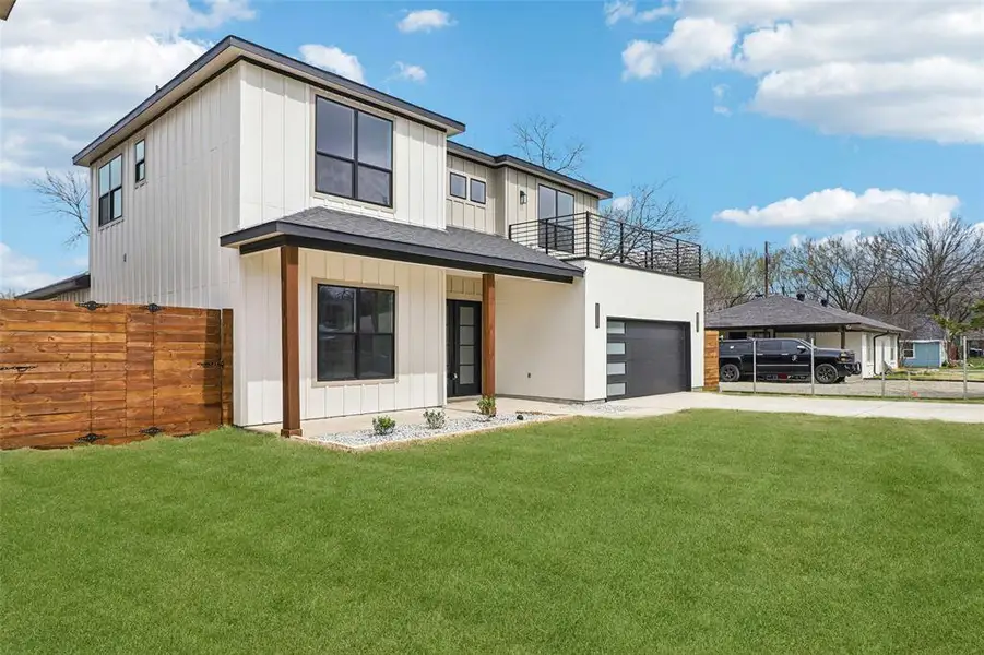 View of front of property featuring driveway, an attached garage, board and batten siding, and covered porch