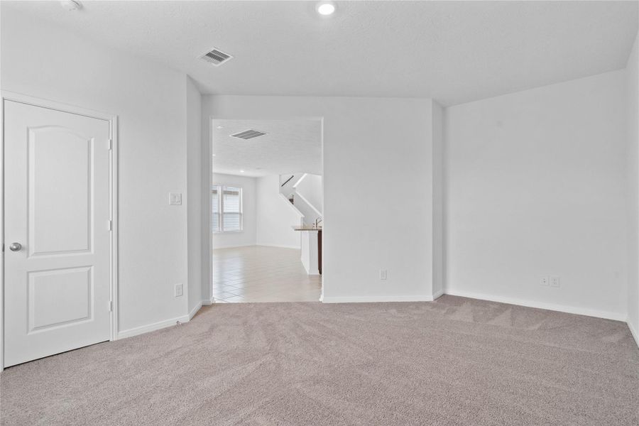 The Den features custom neutral paint, recessed lighting, large window with blinds, closet space, and plush carpet flooring.