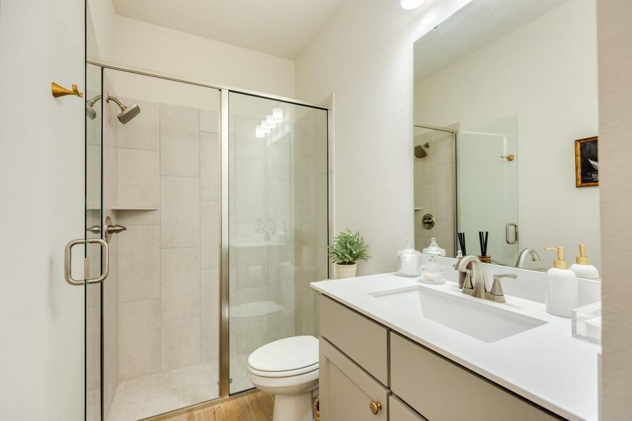 Guest bathroom adjacent to the guest bedroom, featuring a convenient glass walk in shower, elegant quartz countertops, and durable tile flooring. Guest bathroom adjacent to the guest bedroom, featuring a convenient glass walk in shower, elegant quartz countertops, and durable tile flooring.