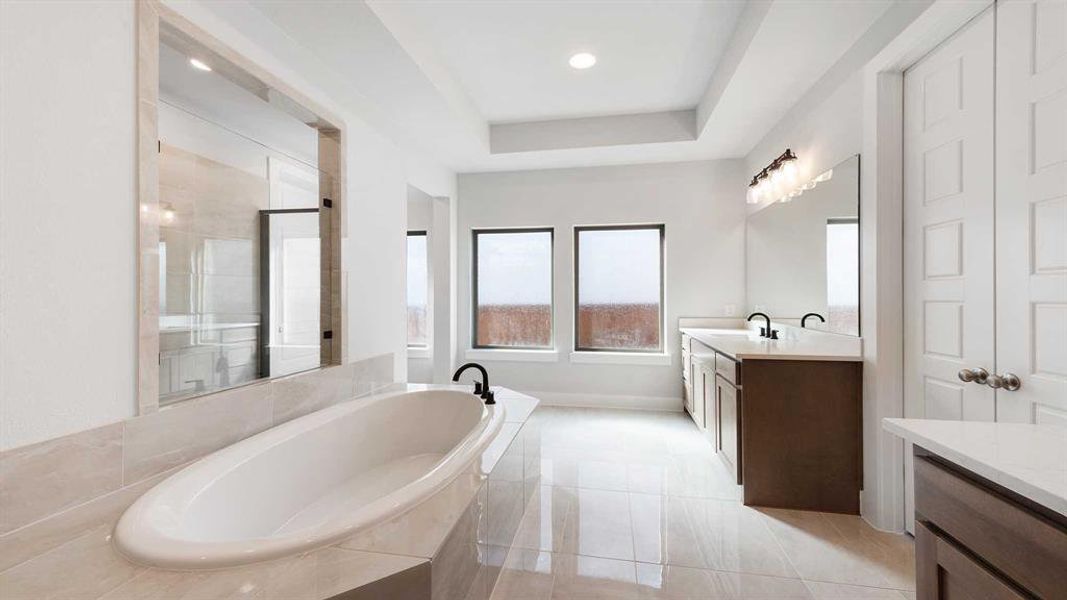 Bathroom featuring separate shower and tub, vanity, a raised ceiling, and tile patterned flooring