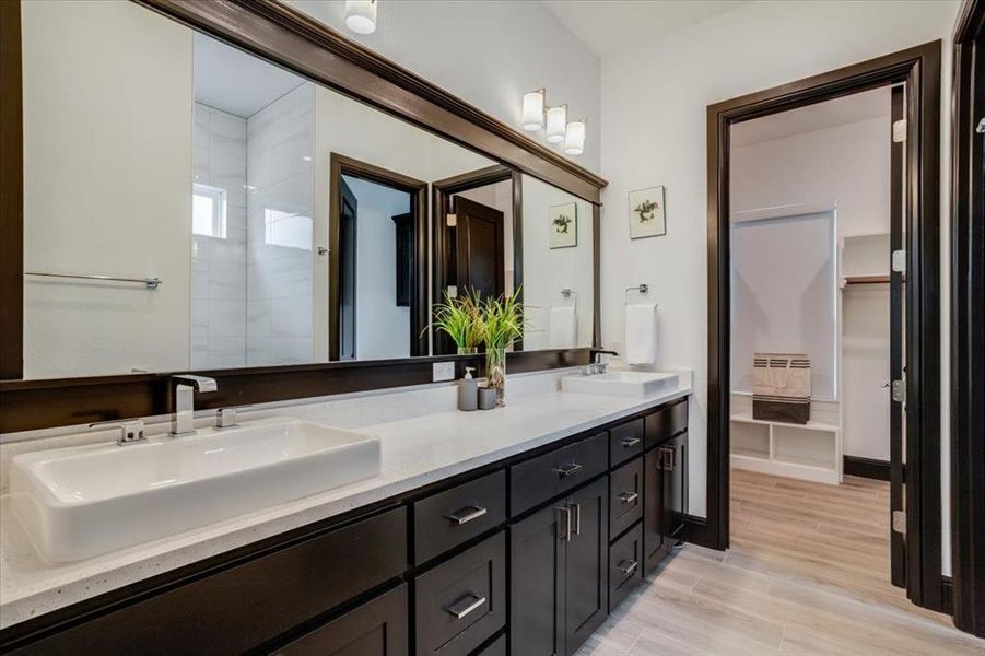 Bathroom with double vanity and light tile finished floors