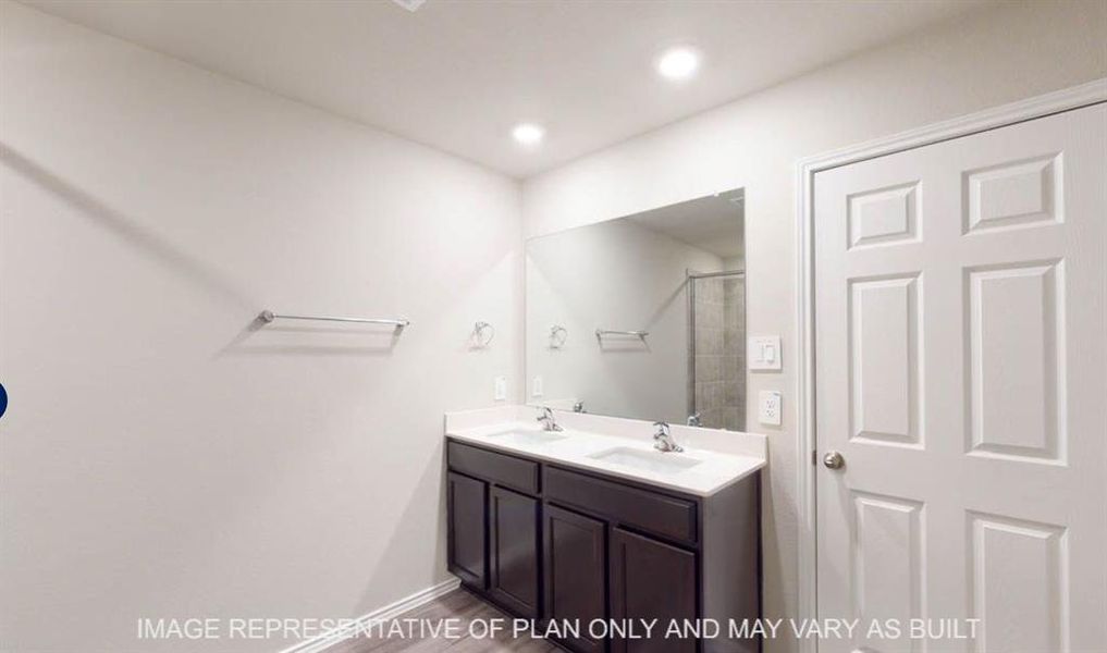 Double vanity with dark wood-finish cabinetry, white countertop, and integrated sinks Double vanity with dark wood-finish cabinetry, white countertop, and integrated sinks
