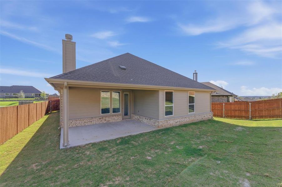 Rear view of property with a fenced backyard, a patio, roof with shingles, and a chimney