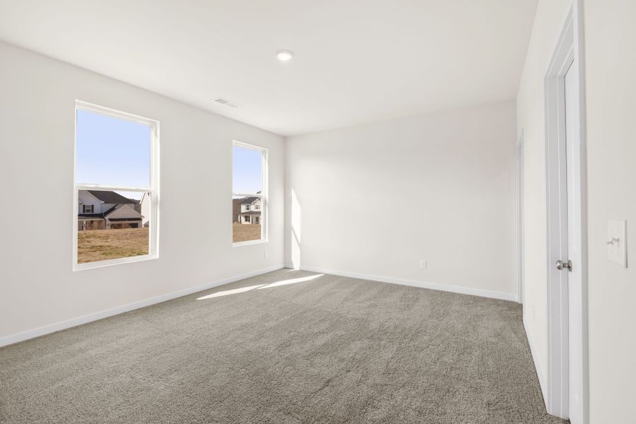 A room with a carpet and a window.