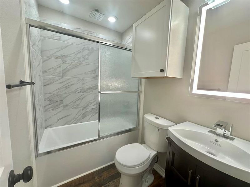 Upstairs Full bathroom featuring vanity, bath / shower combo with glass door, and luxury vinyl plank flooring Upstairs Full bathroom featuring vanity, bath / shower combo with glass door, and luxury vinyl plank flooring