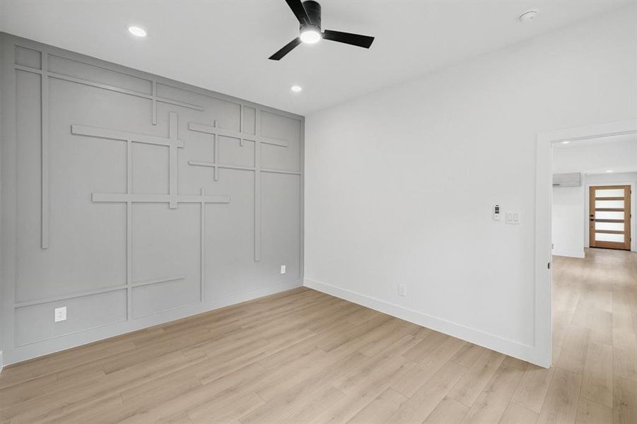 Unfurnished bedroom with light wood-style flooring, a closet, ceiling fan, recessed lighting, and a decorative wall