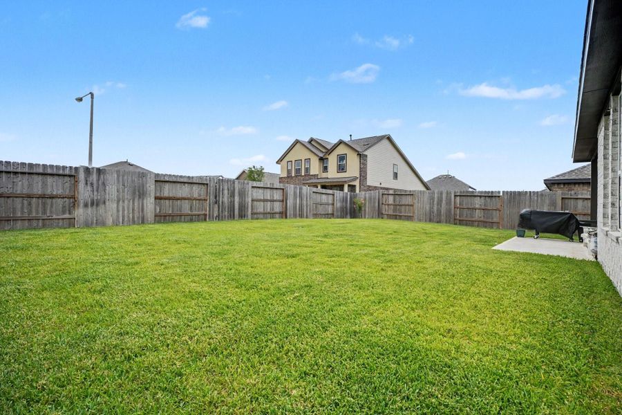 Alternate view of the backyard showcasing the spacious lawn and fully fenced yard. Alternate view of the backyard showcasing the spacious lawn and fully fenced yard.