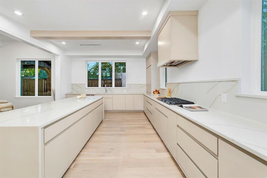 Kitchen featuring modern cabinets, light stone countertops, light wood-style floors, recessed lighting, and custom exhaust hood Kitchen featuring modern cabinets, light stone countertops, light wood-style floors, recessed lighting, and custom exhaust hood