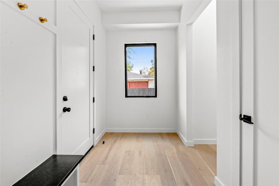 Hallway featuring light wood-style flooring and baseboards
