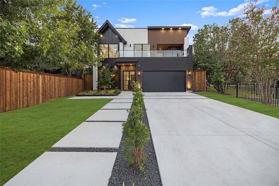 Contemporary home featuring a balcony, concrete driveway, a garage, and board and batten siding Contemporary home featuring a balcony, concrete driveway, a garage, and board and batten siding