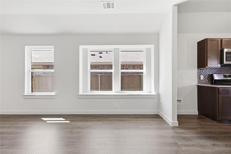 Unfurnished dining area featuring dark wood-style flooring and plenty of natural light