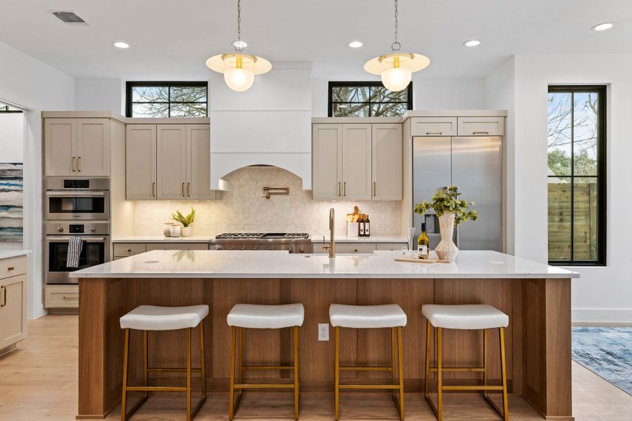 Kitchen featuring stainless steel appliances, decorative backsplash, plenty of natural light, recessed lighting, and hanging light fixtures