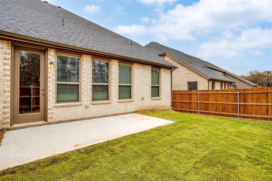 Back of property featuring a lawn and a patio