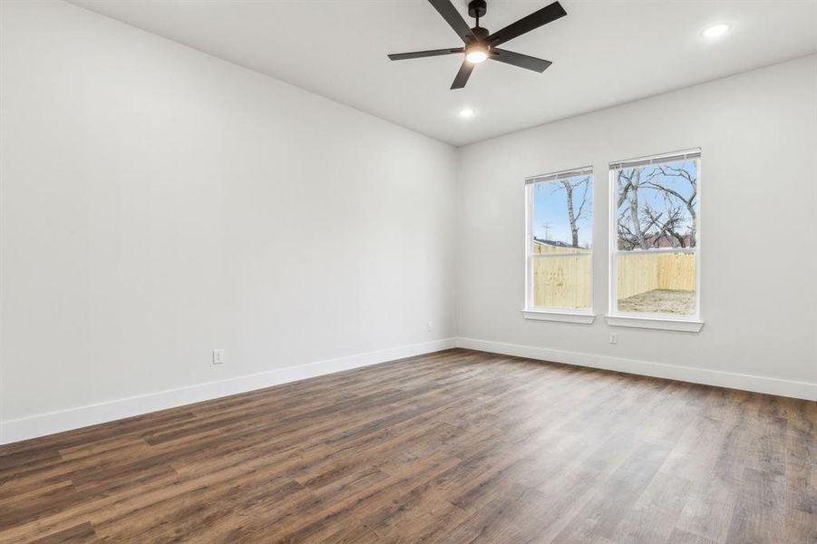 Unfurnished room featuring dark wood-type flooring and ceiling fan