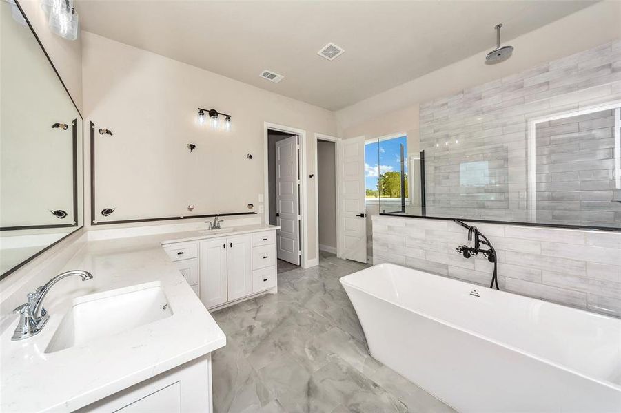 Bathroom with a bath, vanity, tile patterned floors, and tile walls