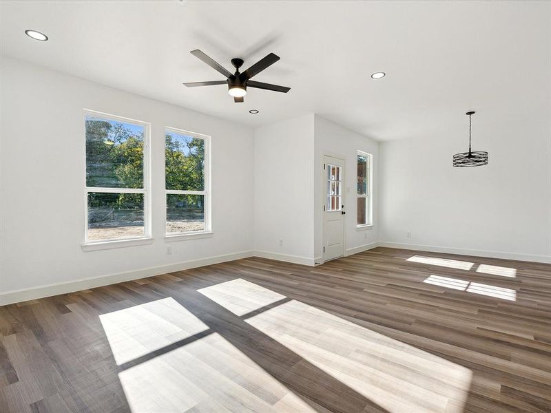 Unfurnished living room with dark hardwood / wood-style floors and ceiling fan