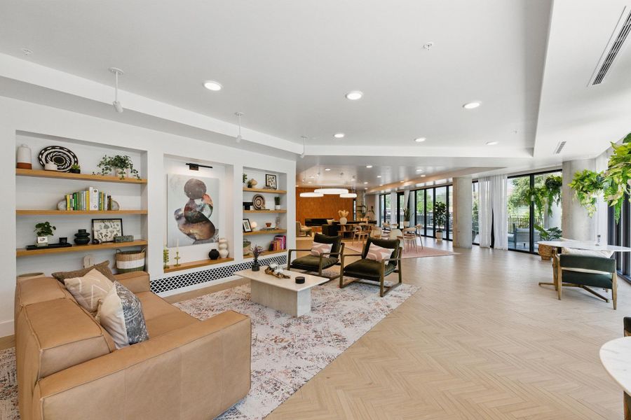 Herringbone hardwood floors extend throughout this grandly scaled living space, offering abundant natural light.