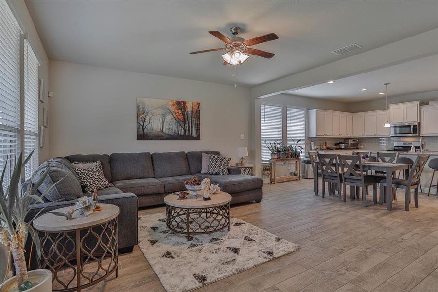 Living area with light wood finished floors, ceiling fan, and recessed lighting Living area with light wood finished floors, ceiling fan, and recessed lighting