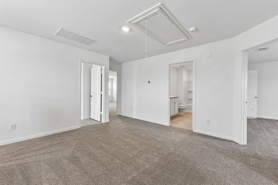 Carpeted room featuring white painted walls and multiple doorways