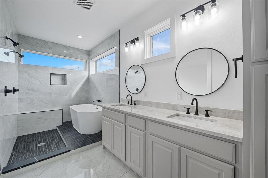 Full bath featuring healthy amount of natural light, a freestanding tub, double vanity, and walk in shower Full bath featuring healthy amount of natural light, a freestanding tub, double vanity, and walk in shower