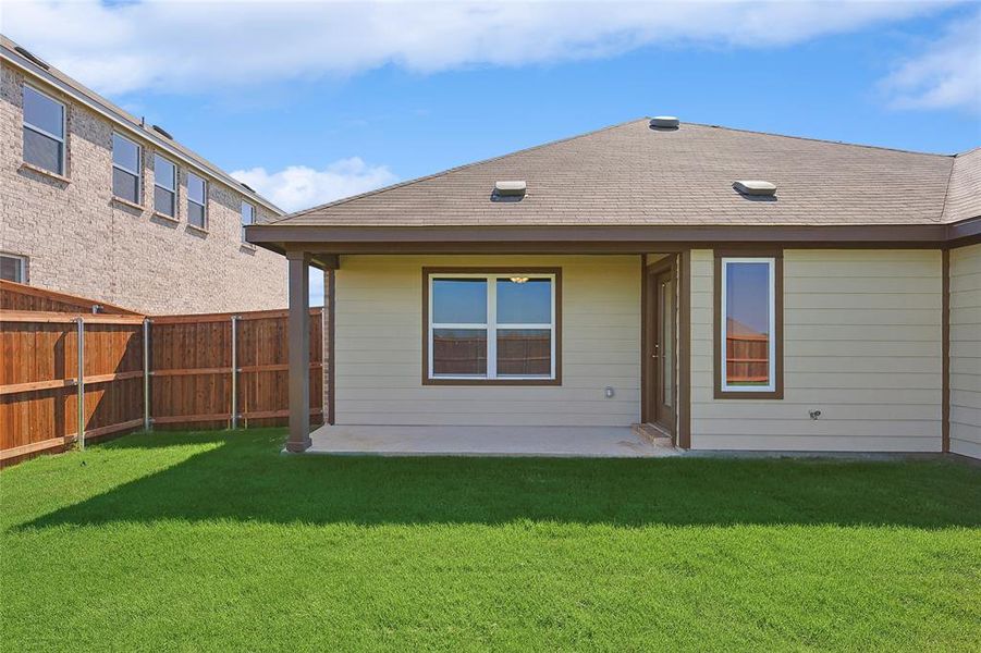 Back of property featuring a lawn and a patio area