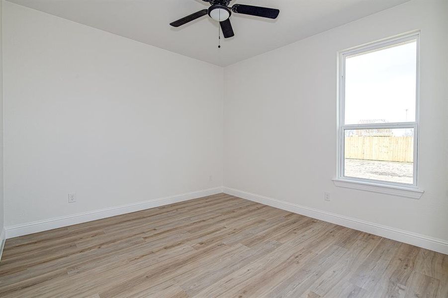 Spare room with light wood-type flooring and ceiling fan