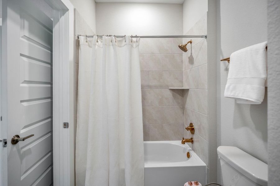 The shared water closet in this Hollywood-style bathroom includes a tub and shower combination, toilet giving both upstairs bedrooms convenient access to a polished, practical space.