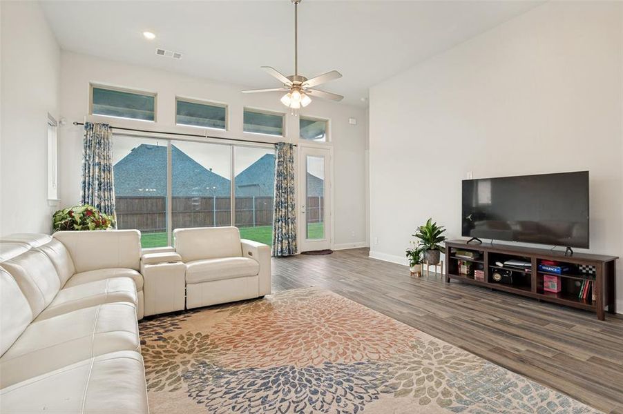 Spacious interior featuring wood-finish flooring, high ceilings, and a ceiling fan with light fixture