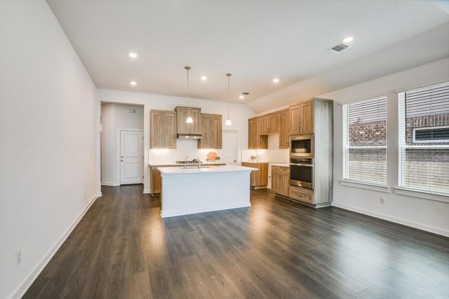 Open-concept kitchen and living area featuring dark wood-finish flooring.