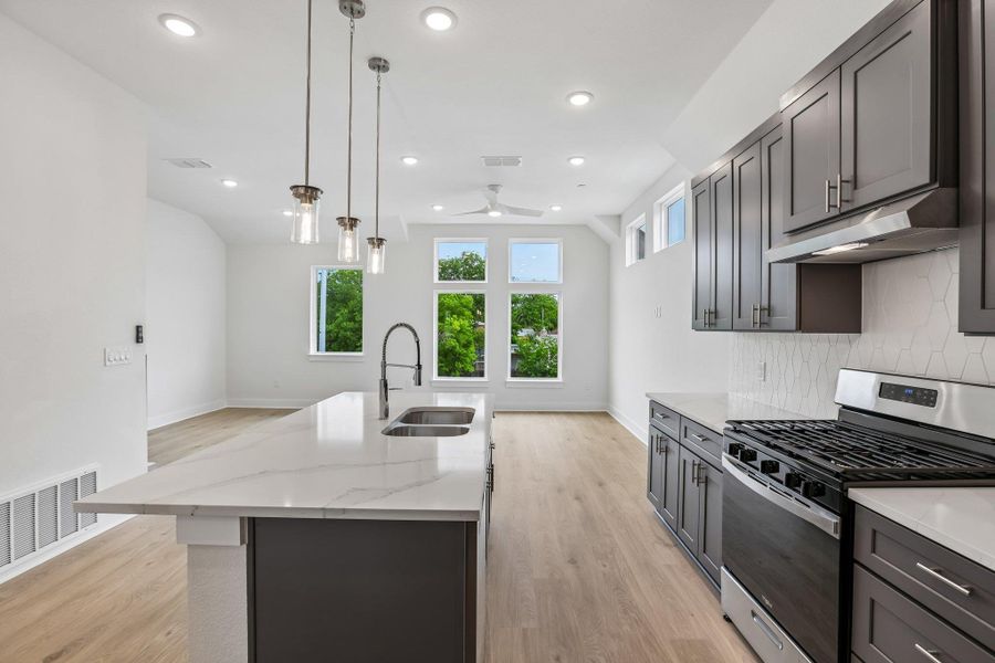 The kitchen is the heart of theliving space, featuring a largequartz island and stylish pendantlights hanging above.