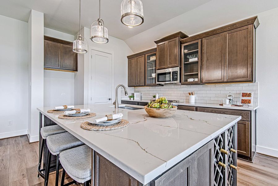 The kitchen island takes center stage with thick, luxe countertops, a built-in wine rack, and stylish pendant lighting. Meal prep or wine night? You’re covered either way. The kitchen island takes center stage with thick, luxe countertops, a built-in wine rack, and stylish pendant lighting. Meal prep or wine night? You’re covered either way.