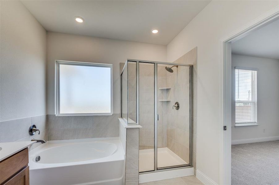 Full bath featuring a garden tub, a shower stall, plenty of natural light, vanity, and recessed lighting