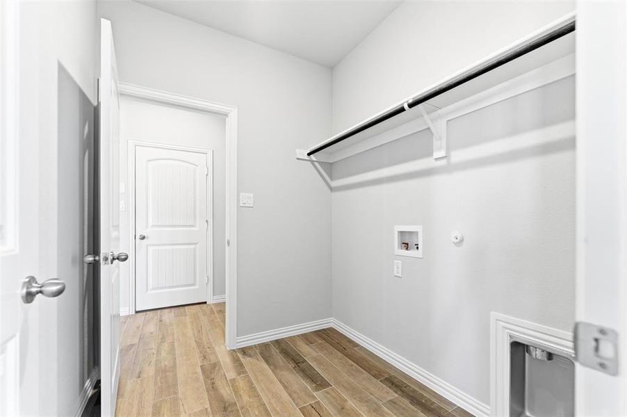 Laundry area with hookup for a gas dryer, light wood-style flooring, and washer hookup