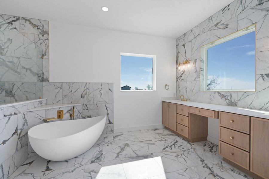 Indulge in a tranquil retreat featuring an elegant freestanding tub and luxurious marble finishes. Indulge in a tranquil retreat featuring an elegant freestanding tub and luxurious marble finishes.