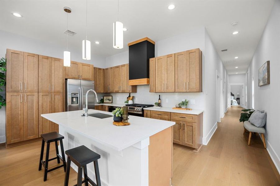 This stunning kitchen has a spacious island with bar seating and conveniently located next to the hallway that leads to the bedrooms.