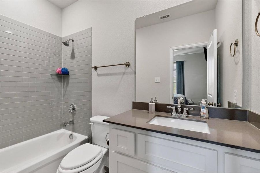 Full bathroom featuring shower / washtub combination, a textured wall, and vanity Full bathroom featuring shower / washtub combination, a textured wall, and vanity