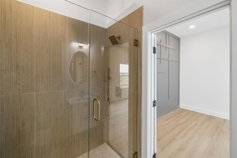 Full bath with a stall shower, wood finished floors, and recessed lighting