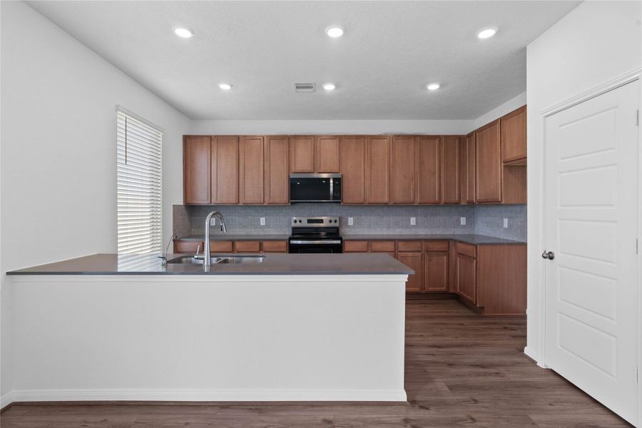 This spacious kitchen has it all—ample storage, generous counter space, and a layout that truly makes it the heart of the home.